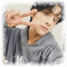a young man is taking a selfie with his hands in the air .