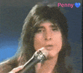 a close up of a man singing into a microphone with the name penny written above him