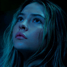 a close up of a woman 's face in a dark room