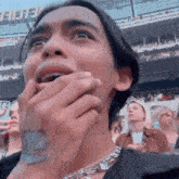 a man is covering his mouth with his hands in a crowd of people at a concert .