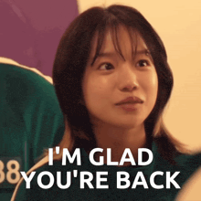 a woman says i 'm glad you 're back in front of a purple wall