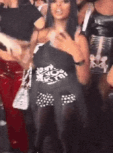a woman is standing in a crowd of people at a party wearing a black shirt .
