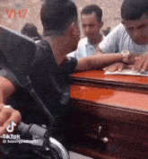 a group of people are sitting around a coffin .