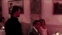 a man and a woman are sitting at a table in a room