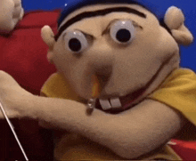 a close up of a puppet with a pencil in his mouth