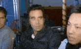 a group of men are sitting in a room and one man is wearing headphones .