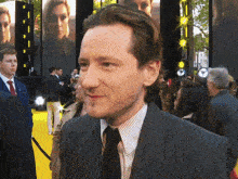 a man in a suit and tie is standing in front of a crowd