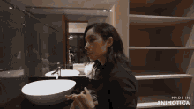 a woman standing in a bathroom with the words made in animatica on the bottom right