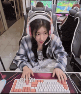a woman wearing headphones sits in front of a keyboard with the letters oh on it