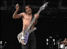 a shirtless man is playing a guitar with a tiger on it