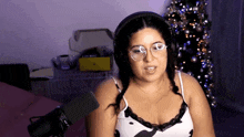 a woman wearing glasses and headphones is standing in front of a microphone