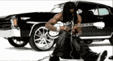 a man is playing a guitar in front of a car
