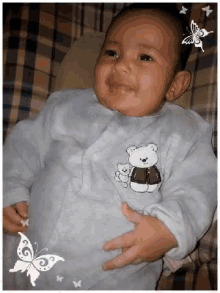a baby with a teddy bear embroidered on his outfit