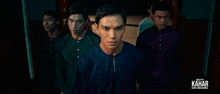 a group of men standing next to each other with the word kahar on the bottom right