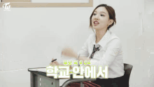 a group of girls are sitting at desks in a classroom with the word twice on the top left