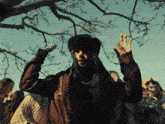 a man in a hooded jacket is standing in front of a group of people