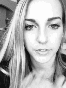 a woman 's face is shown in a black and white photo with a sign in the background that says exit
