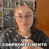 a woman wearing glasses and a shirt that says um compromisetimento