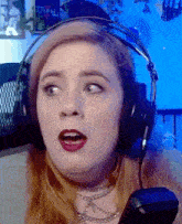 a woman wearing headphones and a choker looks surprised