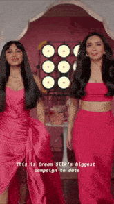 two women in pink dresses are standing next to each other