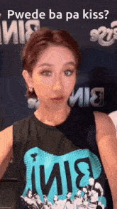 a woman is wearing a shirt that says ' puede ba pa kiss ' on it