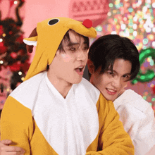 a man in a reindeer costume is hugging another man in a white shirt