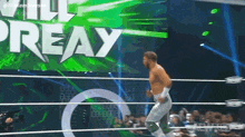 a man in a wrestling ring with the word preay on the wall behind him
