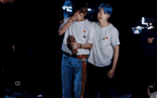 a man with blue hair is standing next to another man with blonde hair