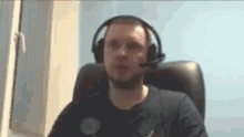 a man wearing headphones and a headset is sitting in a chair .