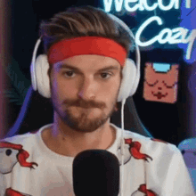 a man wearing headphones and a red headband is looking at the camera .