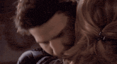 a woman is hugging a man with her eyes closed and a tear running down her face
