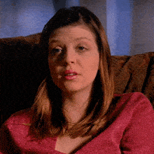 a woman in a pink top is sitting in a chair