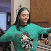 a girl with green hair is wearing a green sweatshirt with a picture of izuku midoriya on it
