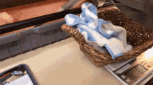 a wicker basket with a towel in it sits on top of a digital scale that shows a weight of 10 grams