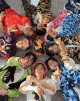 a group of young men are laying in a circle with their fingers up