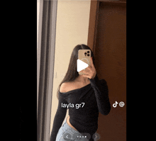 a girl is taking a picture of herself in a mirror with the name layla gr7 on the bottom