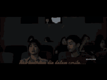 a group of people are watching a movie in a dark auditorium and the words yang hanya mengisahkan luka are visible