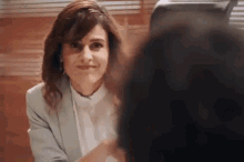 a woman is sitting at a table with a man and looking at him .