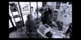 a black and white photo of people in a store with a time stamp of 16:10 19:12