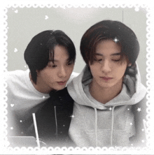 a couple of young men standing next to each other with their eyes closed .