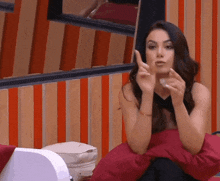 a woman sitting on a red pillow making a funny face