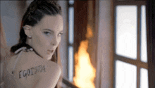 a woman has the word egoista written on her back