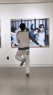 a man in white pants with the letter d on the back is standing in front of a large picture