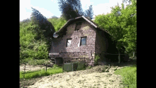 a small brick house in the middle of a field