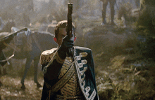 a man in a military uniform is pointing a gun