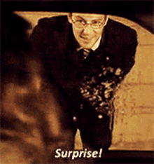 a man in a suit and tie says surprise on the screen