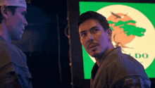 two men are standing in front of a screen that says do on it