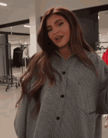 a woman in a plaid shirt is standing in a store