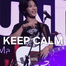 a man singing into a microphone while holding a guitar with the words keep calm written on the bottom