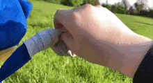 a person is holding a stuffed animal 's hand in a park .